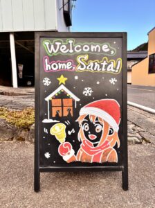 ブラックボードに「ウェルカムﾎｰﾑサンタ」
