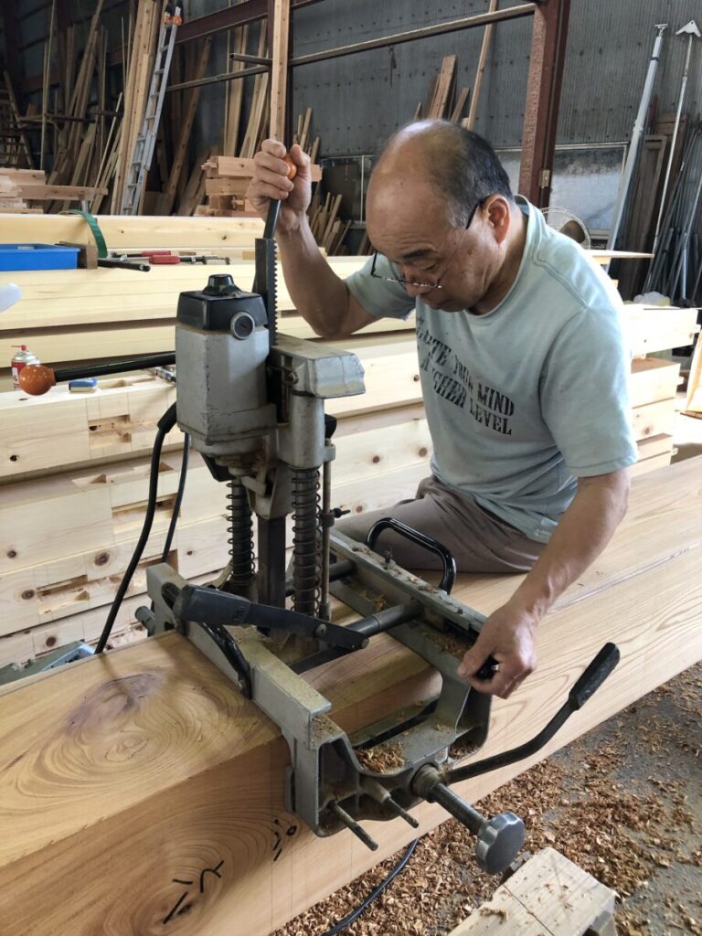 大工さんがホゾトリ機で穴を開けている様子。